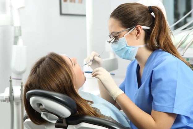Dentist performing dental bonding to repair chips, gaps and worn edges