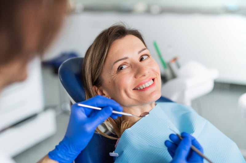 Woman receiving a dental check-up to assess her candidacy for All-on-X dental implants
