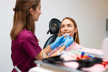 Dentist selecting porcelain veneer shade during veneer consultation in Markham dental clinic.