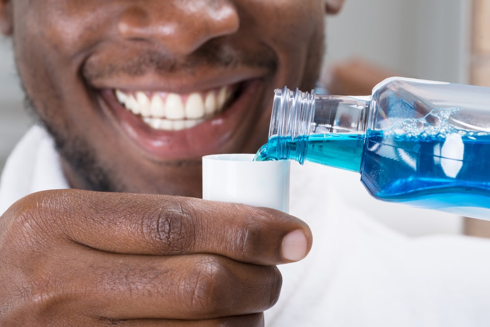 Close-up of a man pouring mouthwash into a cap