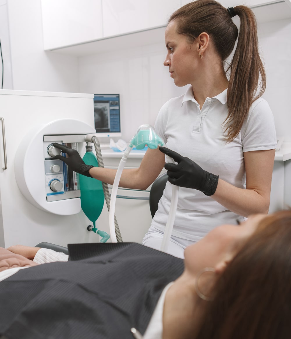 Woman reclining in a dentist chair during sedation-assisted dental treatment