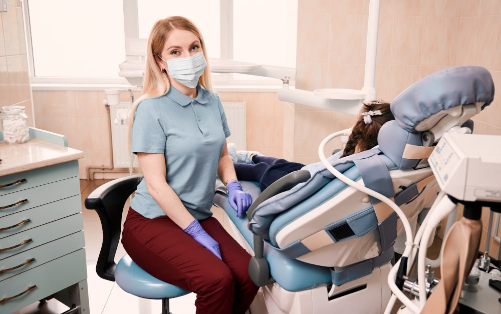 Child at dental clinic with pediatric dentist discussing sedation options